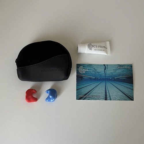 Ear plugs with case, swim plug instructions, and cream tube on a white background.