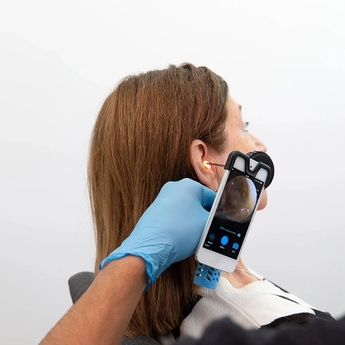Medical professional using mobile otoscope to examine woman's ear for ear health assessment.