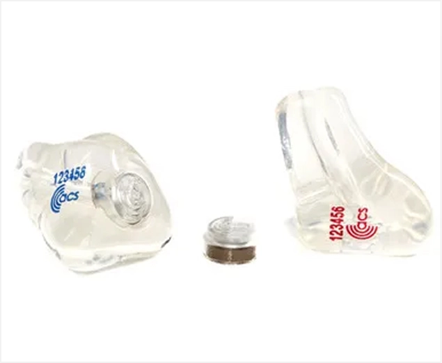 Custom earplugs with filters for noise reduction and hearing protection, labeled with serial numbers and brand logo.