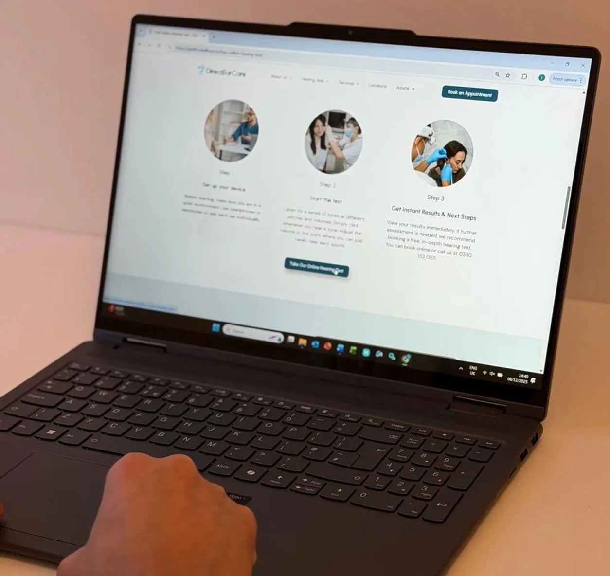 Person using a laptop to view a healthcare appointment website.